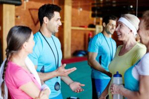 personal trainer conversa com alunas no ginásio